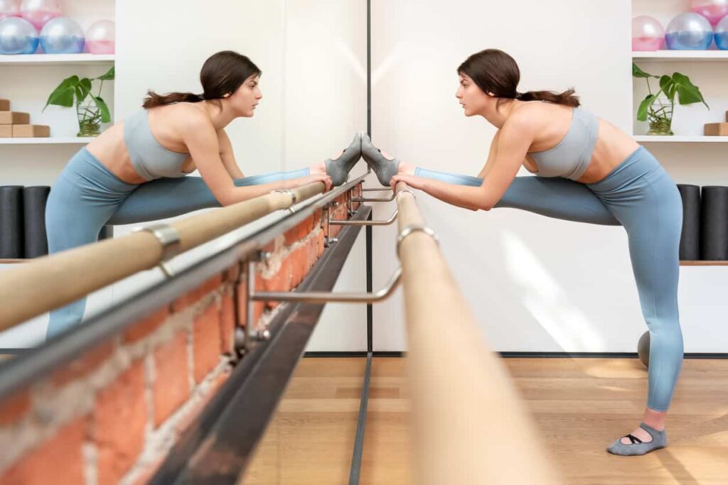 exercice souplesse : femme réalisant des exercices de souplesse sur une barre