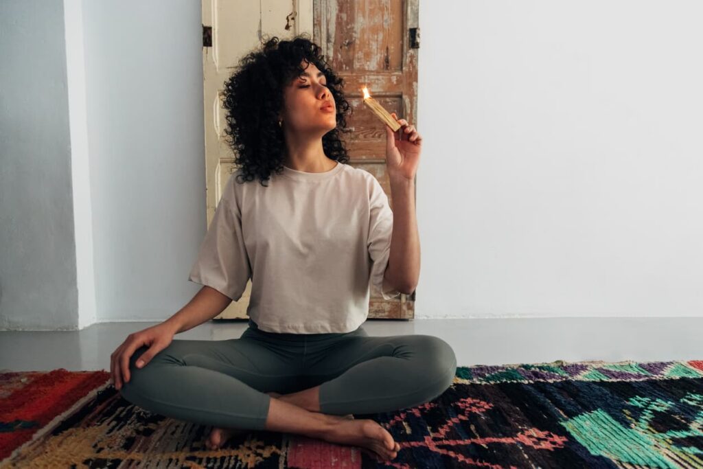 femme en position de yoga avec un encens pour lutter contre la fatigue