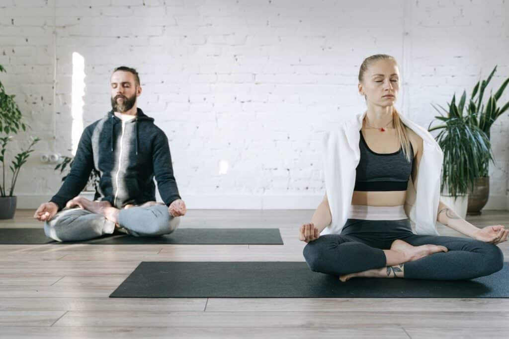 homme et femme qui se détendent pendant une session de yoga