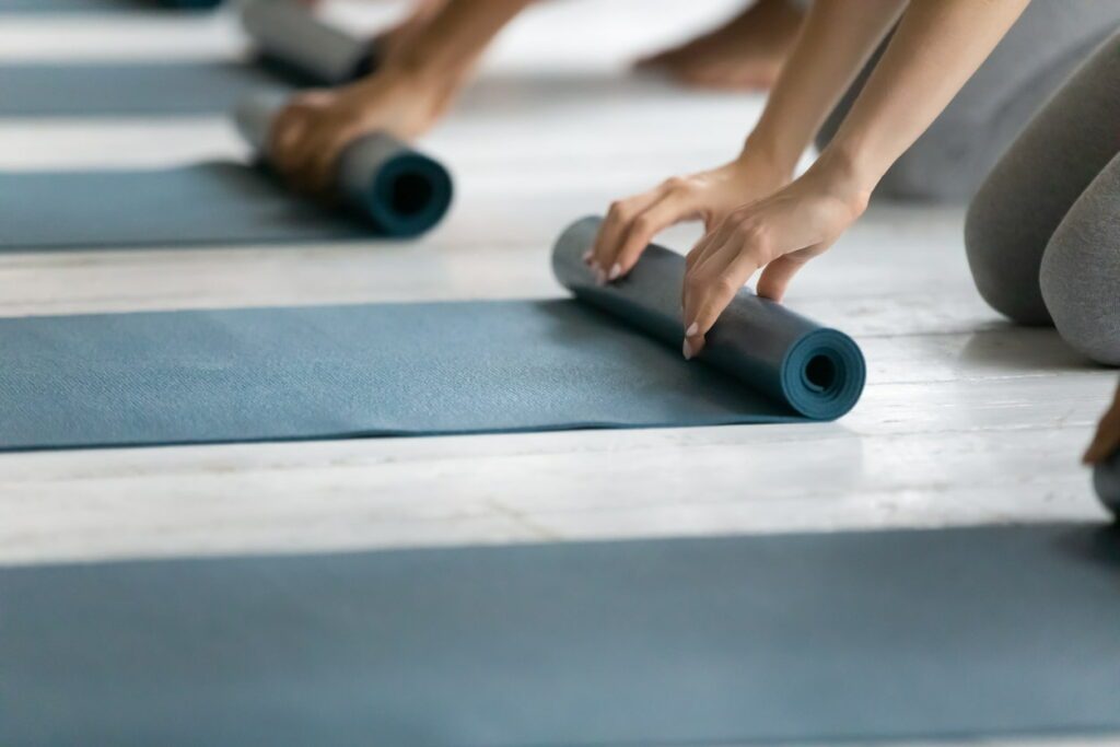 bienfaits du pilates : personnes qui déroulent un tapis de pilates