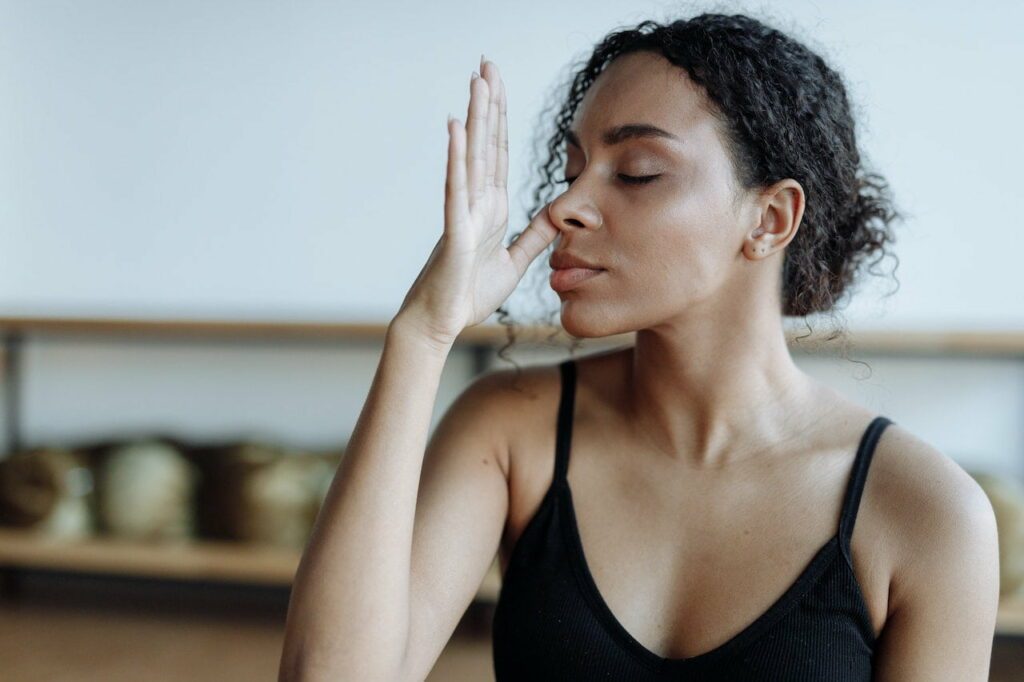 yoga respiration pranayama : une jeune femme pratiquant un pranayama