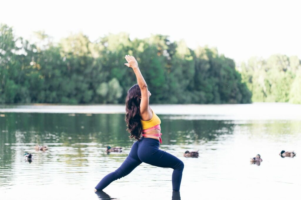 aqua yoga : une femme fait une posture de yoga dans un lac