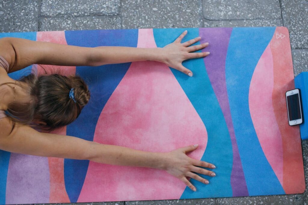 restorative yoga : une femme s'allonge sur un  tapis de ypga