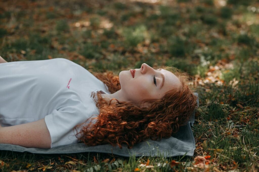 restorative yoga : une femme allongée sur un tapis de yoga