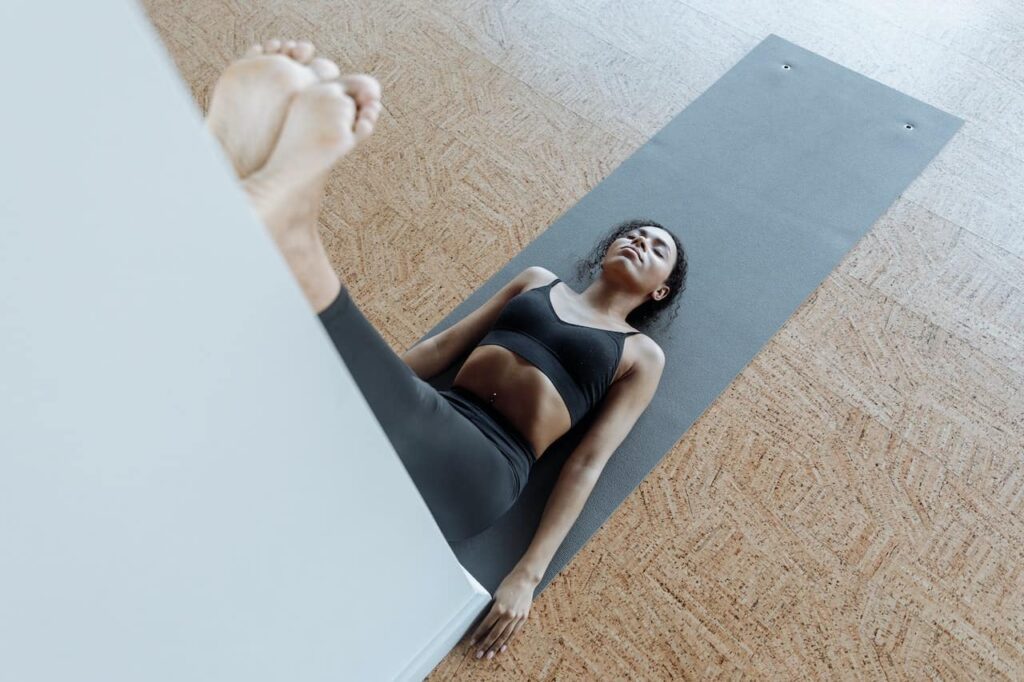 exercices pilates au mur : une femme fait une posture contre un mur