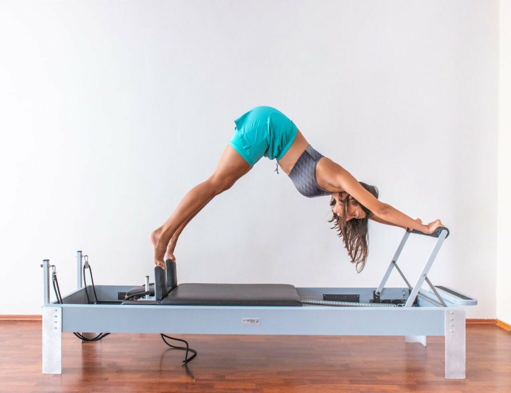 stott pilates : une femme fait un exercice de pilates sur un reformer