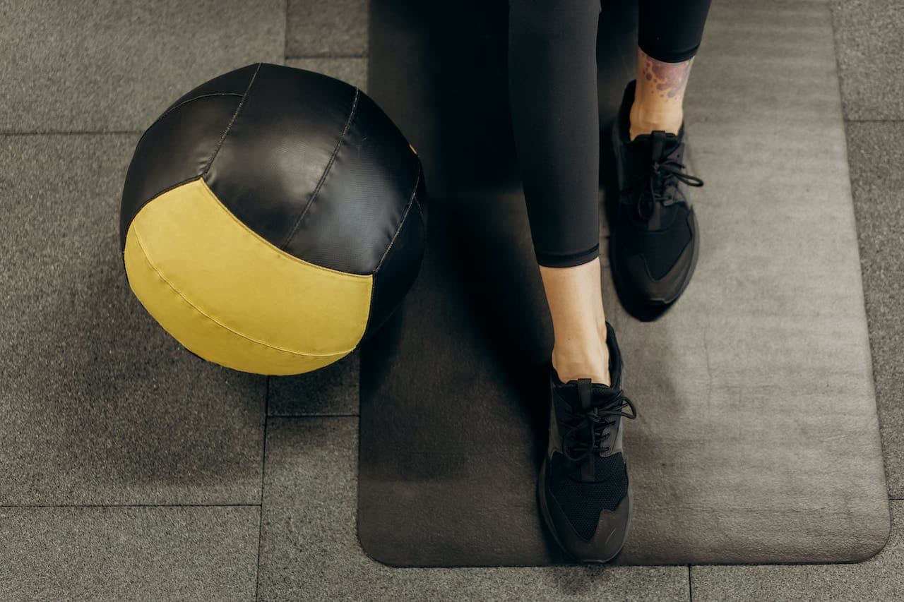 workout pilates : un ballon de pilates aux pieds d'une pratiquante.