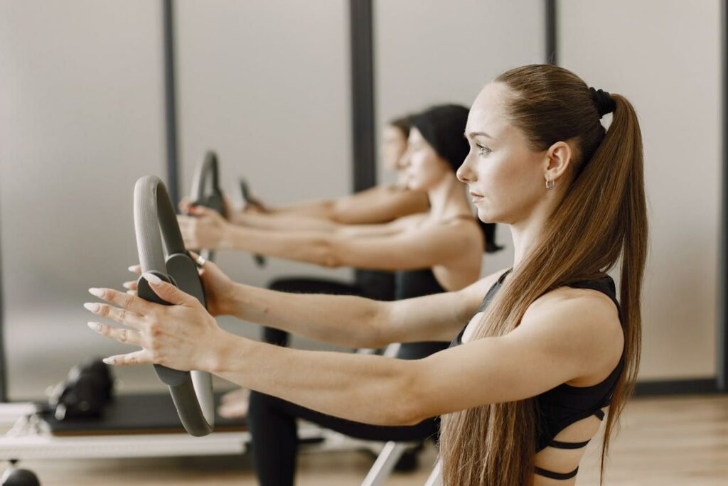 exercices anneau pilates : des femmes tiennent un anneau dans les mains