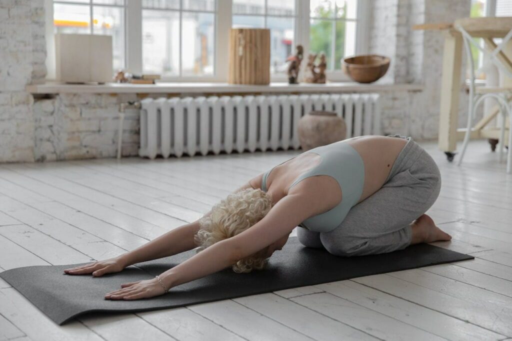 Une femme réalise la posture de l'enfant